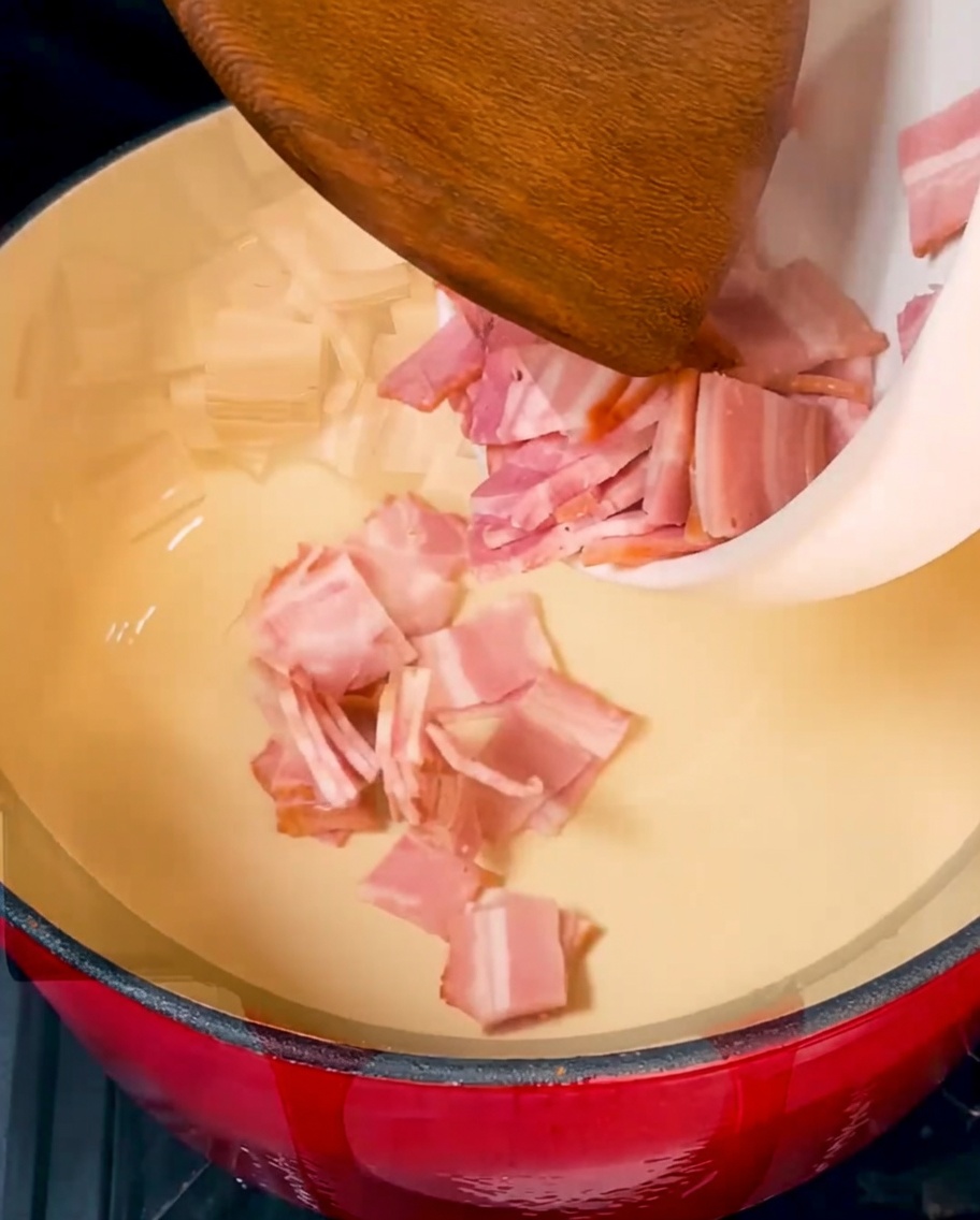 赤いダッチオーブンの中でこんがりと焼かれているベーコン。
