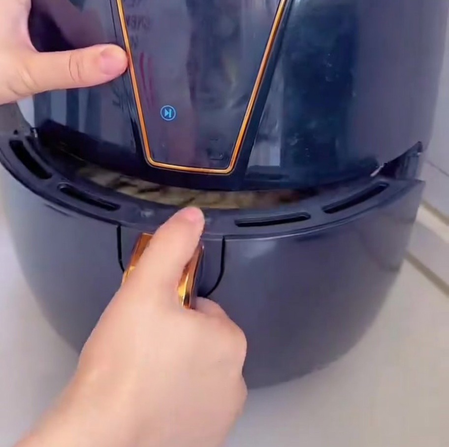 ピザをエアフライヤーのバスケットに入れている様子。