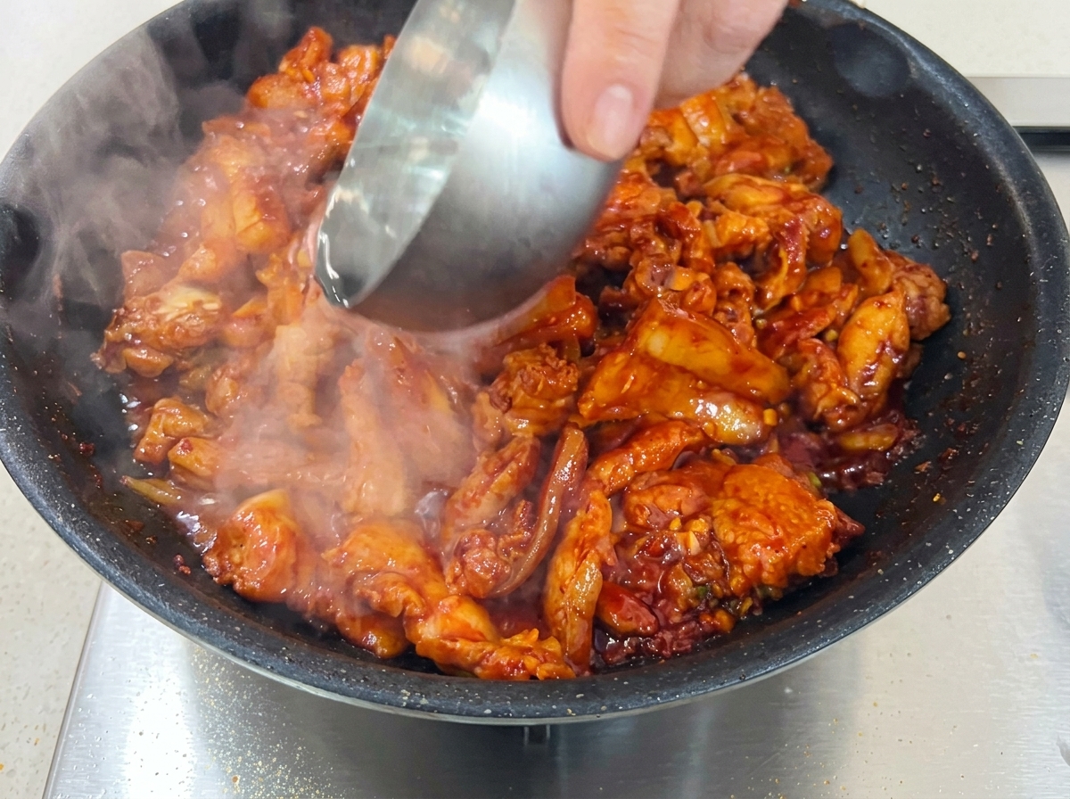 蓋をして、少量の水で煮込まれている豚バラ肉。