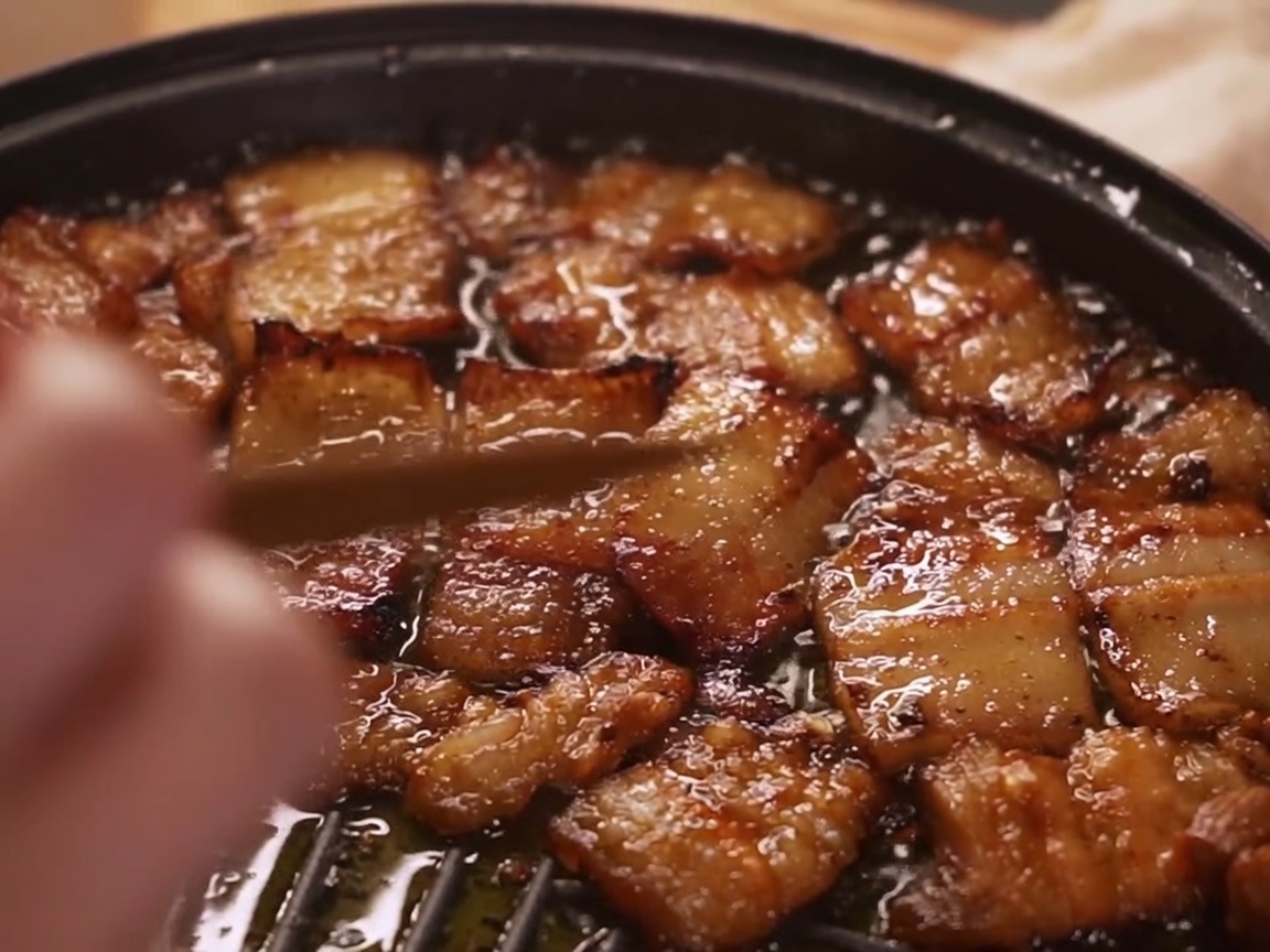 まな板の上で下味をつけるために綺麗に並べられた豚バラ肉の薄切り