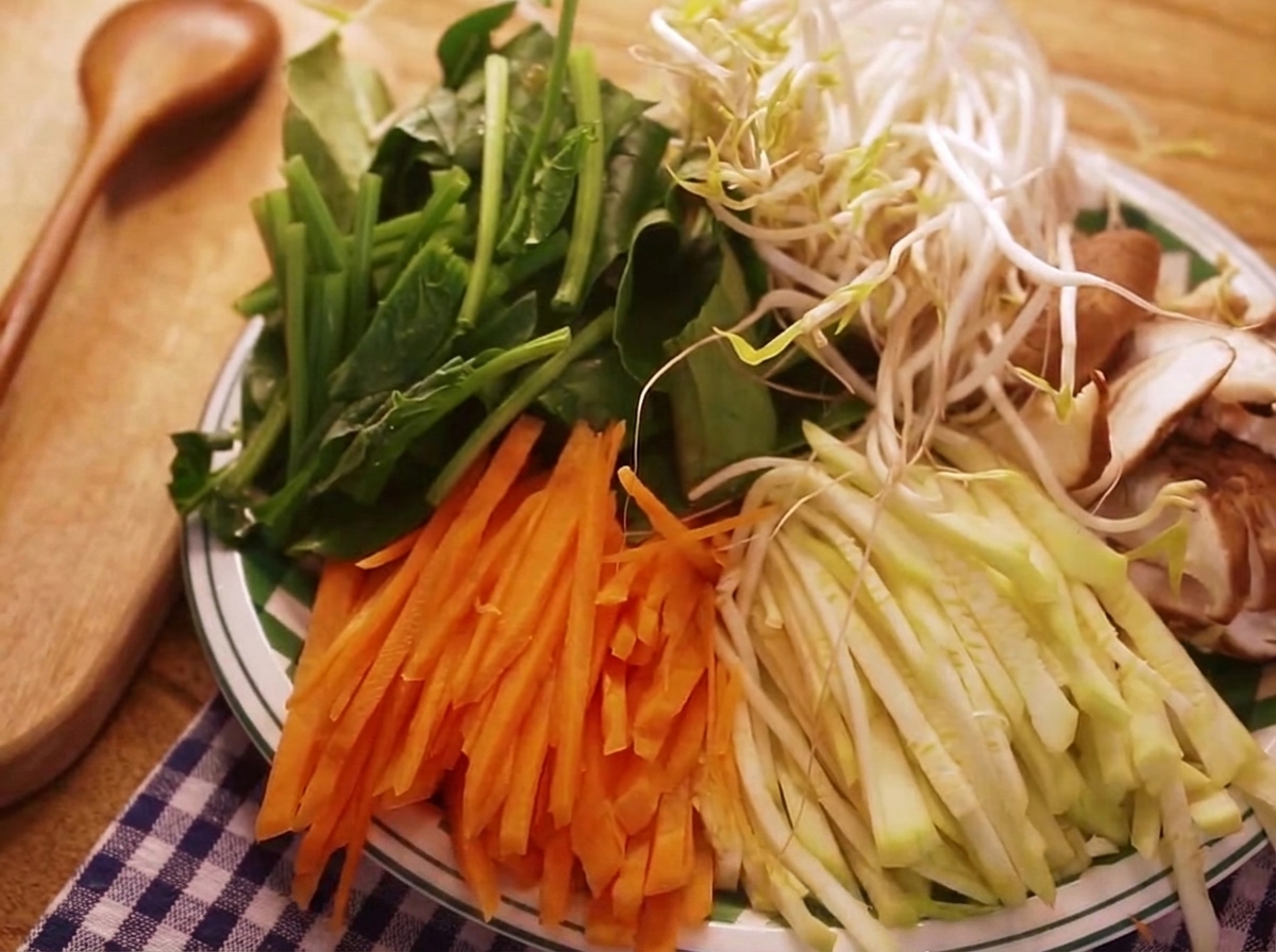 ビビンバ用に準備された、にんじん、ズッキーニ、ほうれん草などの色鮮やかな千切り野菜