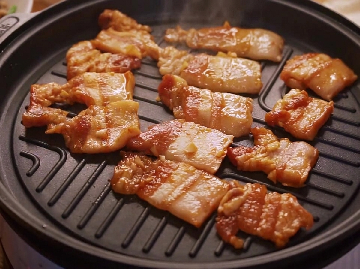 熱したグリルパンで香ばしい焼き目をつけて焼かれるマリネした豚バラ肉