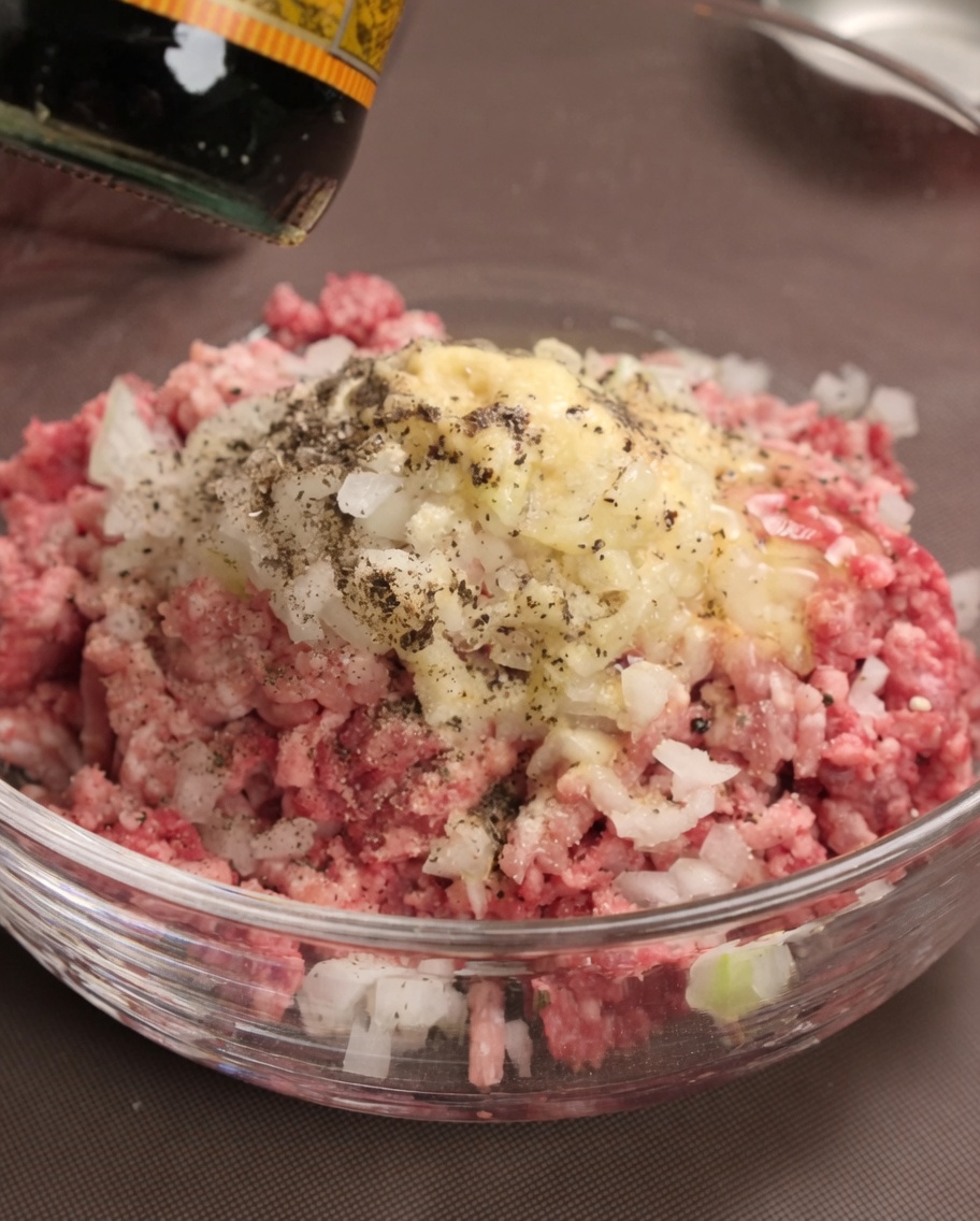 肉だねに調味料とウスターソースを加える様子