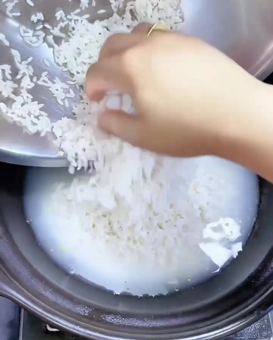熱した石鍋にご飯を入れ、平らに広げている様子。