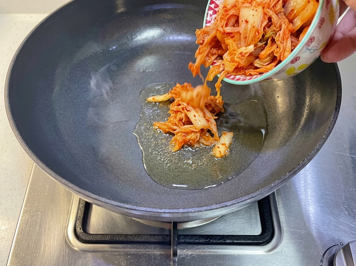 熱したフライパンにキムチを入れる様子。