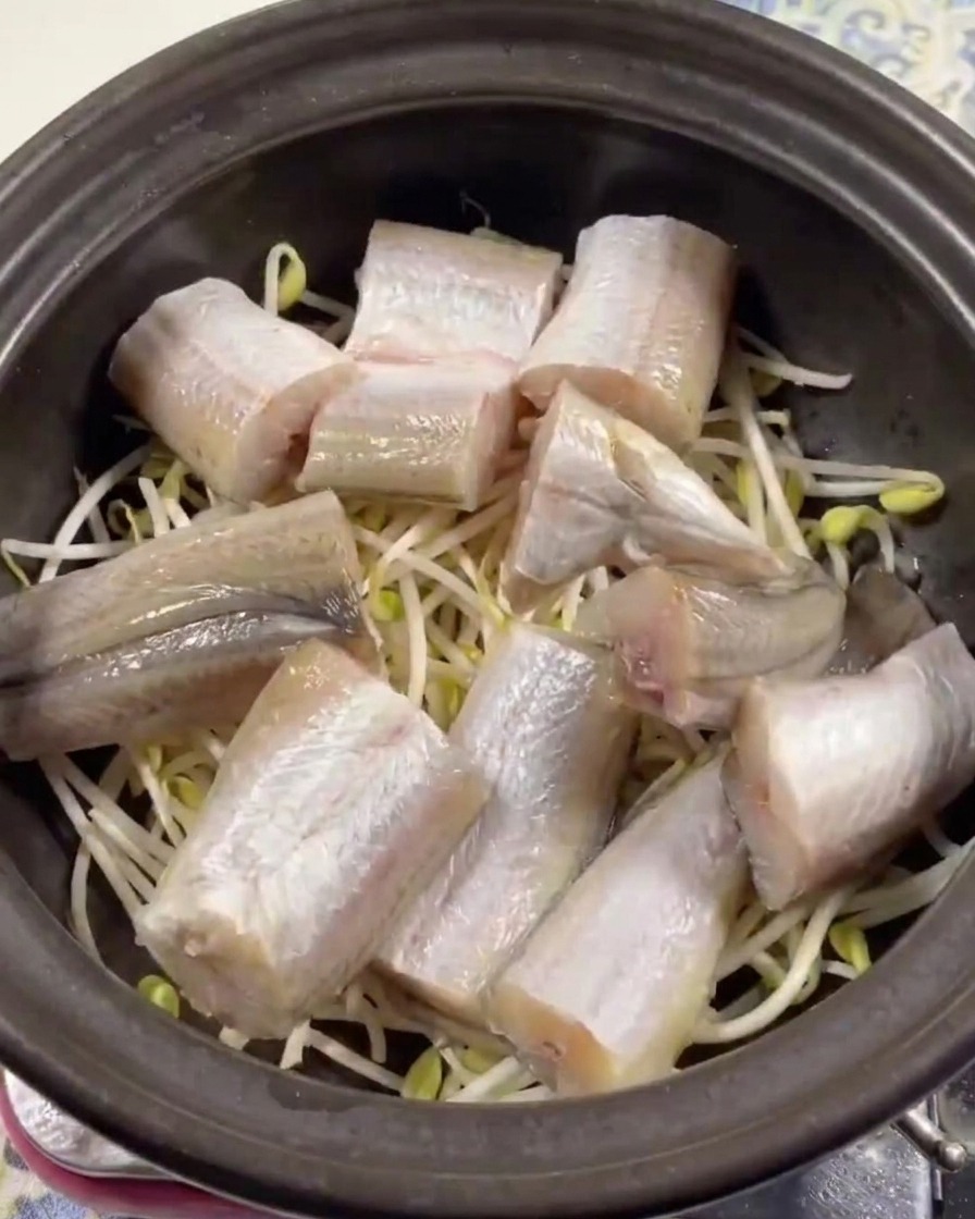 土鍋に敷いた豆もやしの上にスケトウダラを並べている様子。