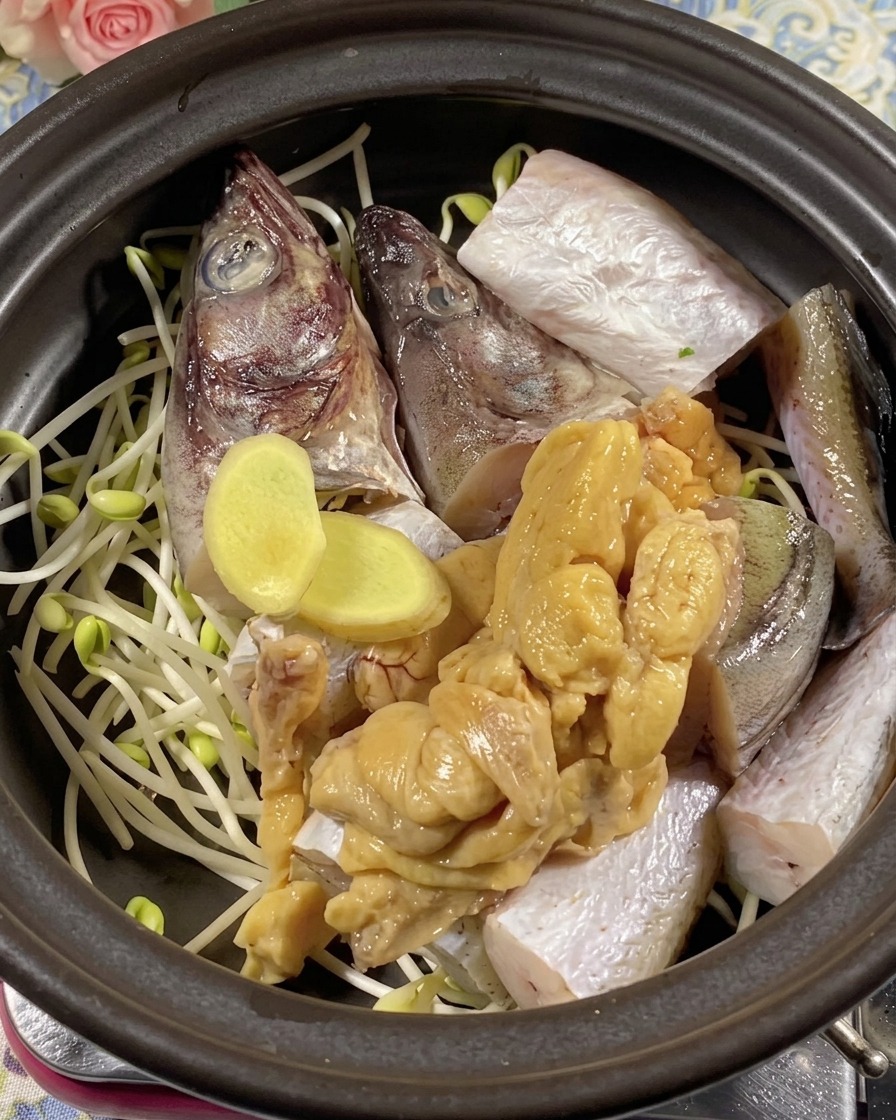 魚の上に生姜スライスとタラの卵を乗せている様子。