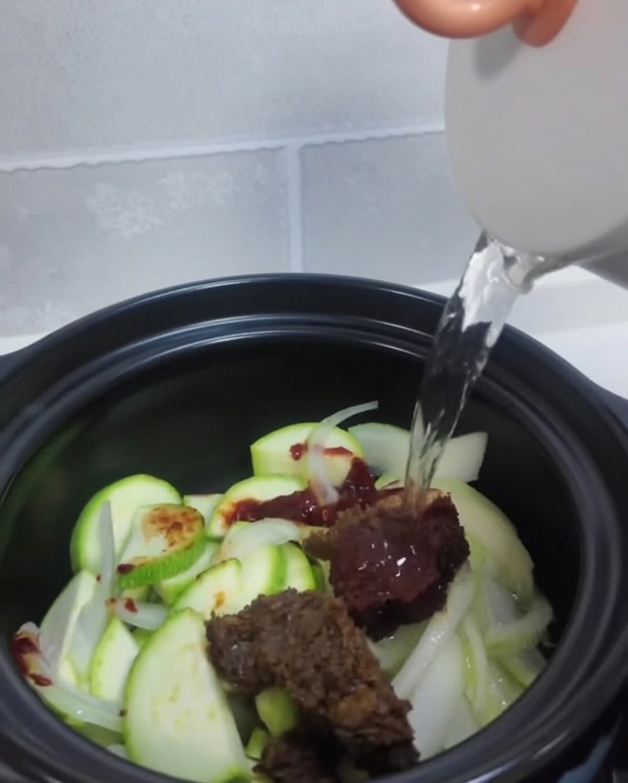 野菜と味噌が入った鍋に、水を入れる様子。