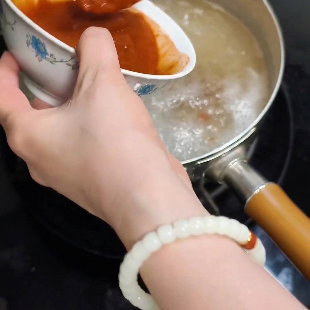 溶かした味噌を鍋に入れる様子