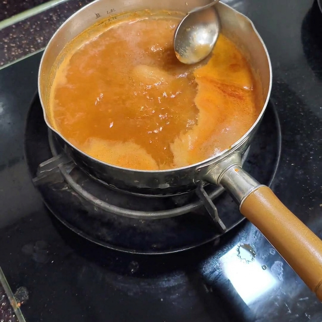 お玉でアクを取る様子
