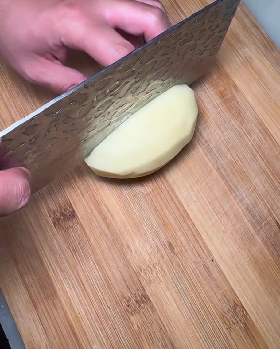 まな板の上に並べられた生のじゃがいものスライス。