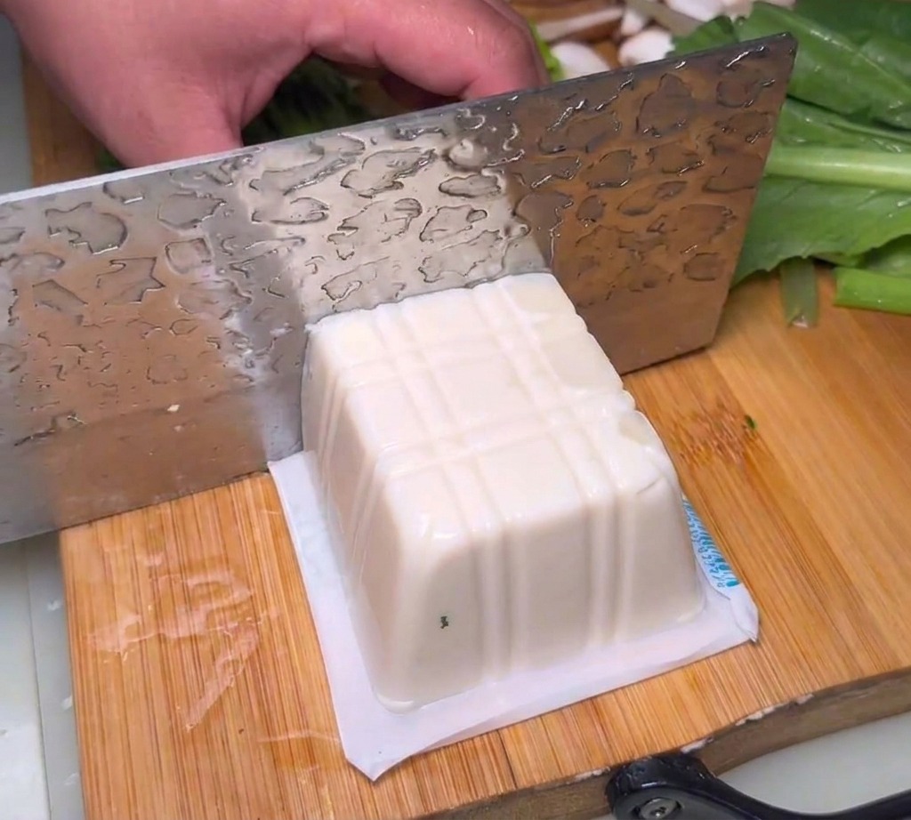 まな板の上で厚切りにされた絹ごし豆腐。