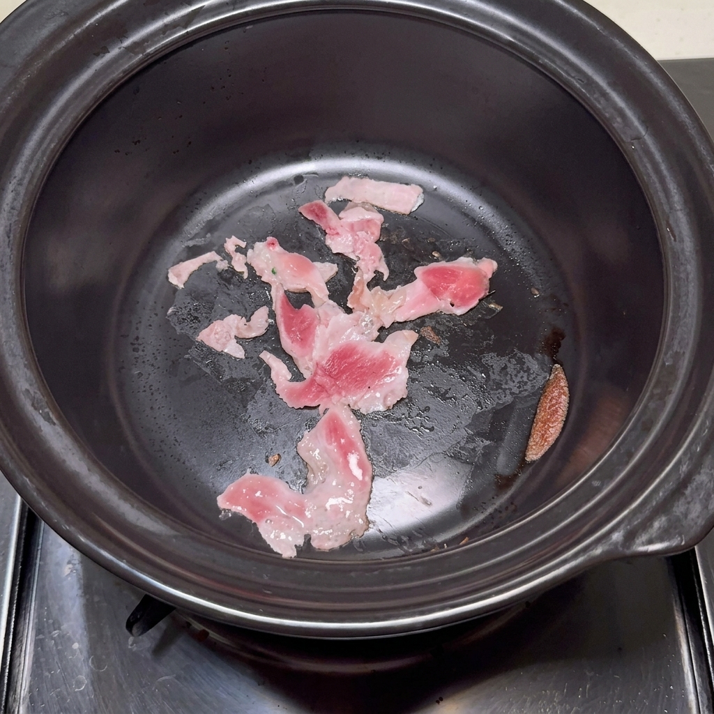 豚肉入りの石鍋に水を加える様子。
