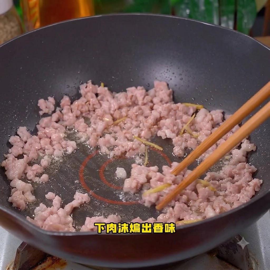中華鍋の中で豚ひき肉を炒めている様子。