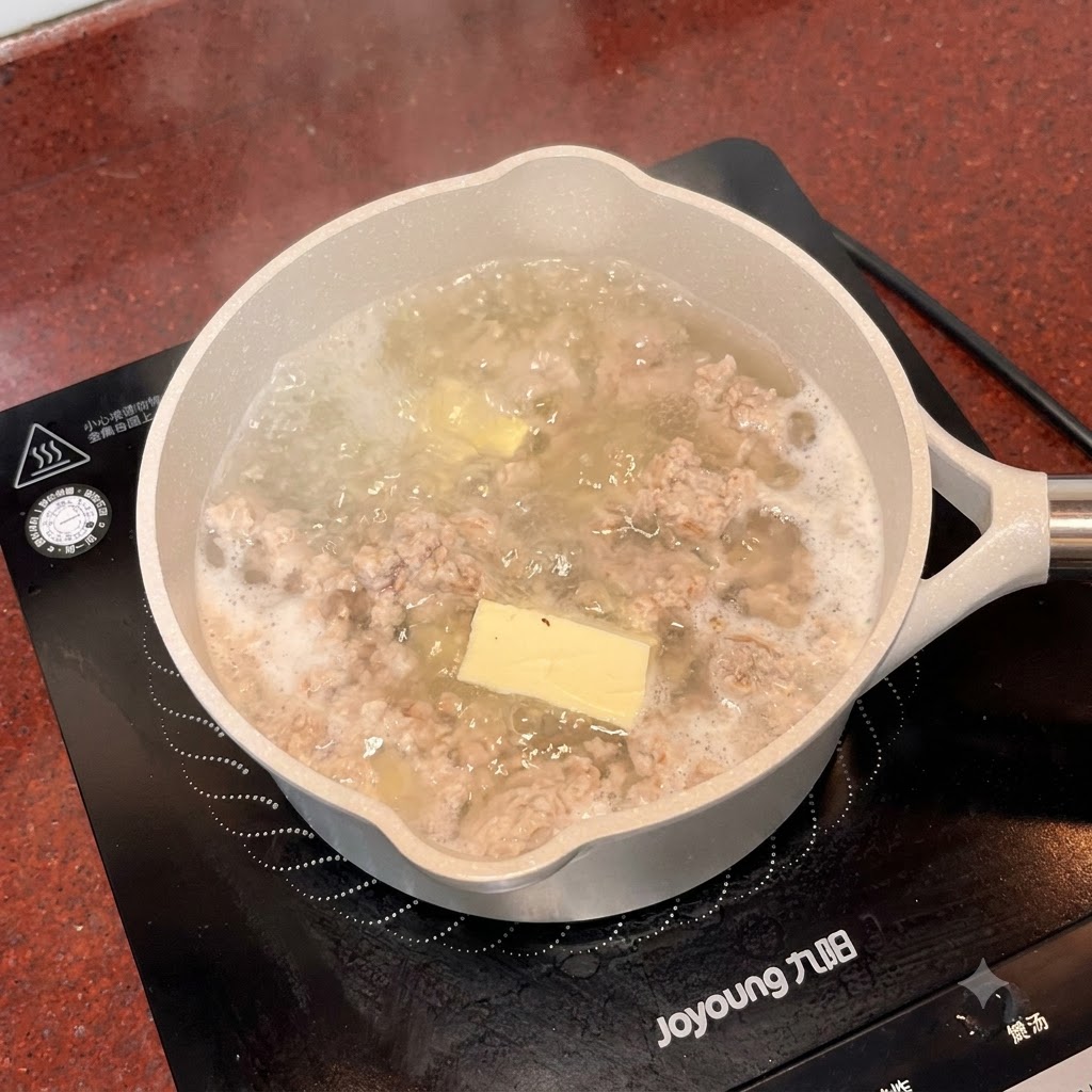 白い小さなスプーンで、塩とうま味調味料がスープの鍋に加えられている様子。