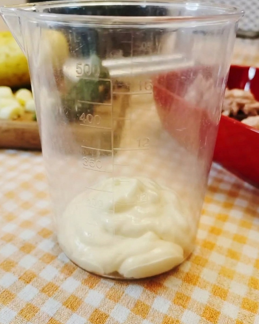 透明な計量カップの底に入った濃厚なマヨネーズ