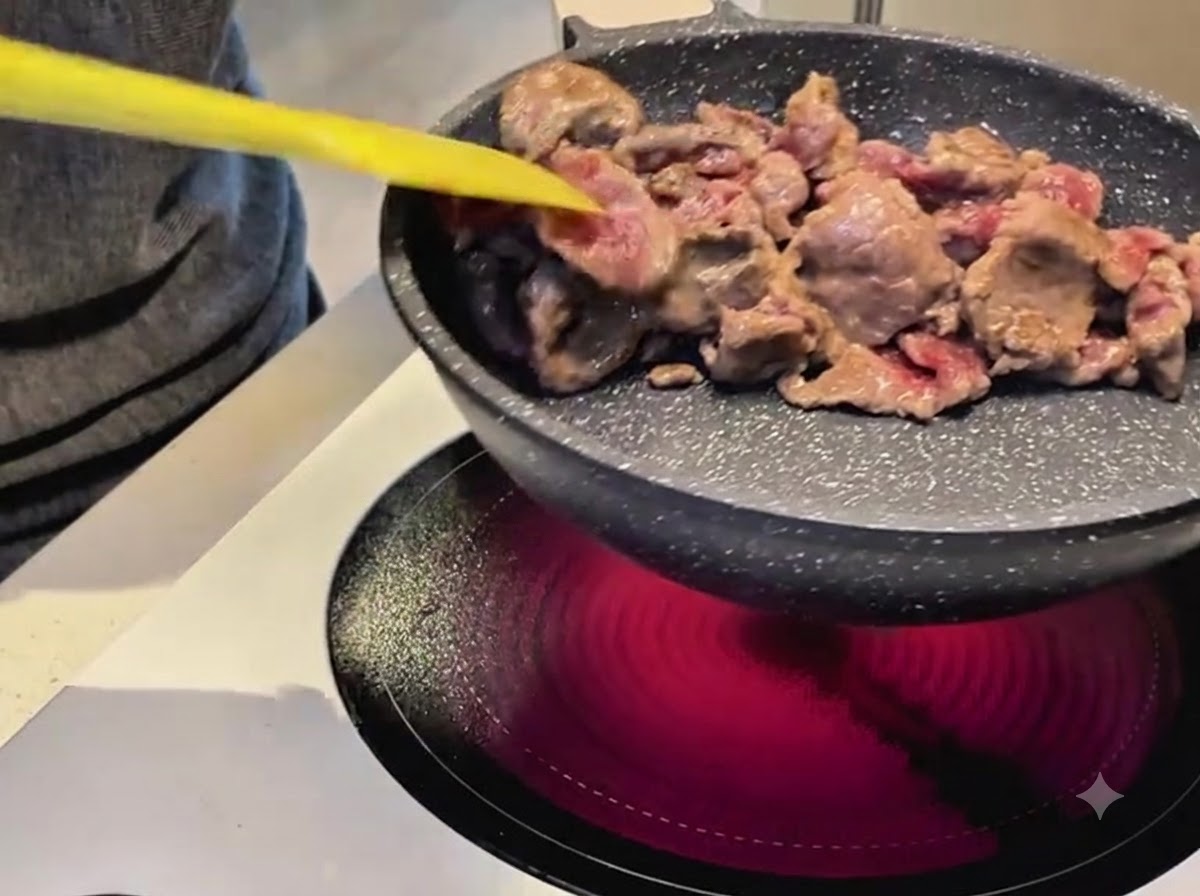 フライパンで牛肉をスパチュラを使って炒めている様子。