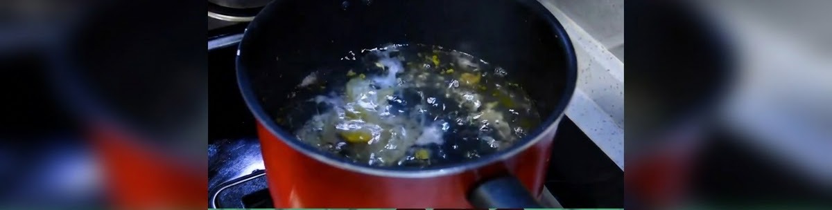 コンロの上で水がボコボコと沸騰しかけている黒い調理鍋。