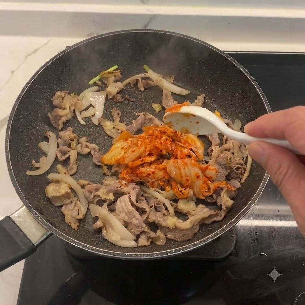 牛肉と玉ねぎの入ったフライパンに混ぜ込まれている刻みキムチ
