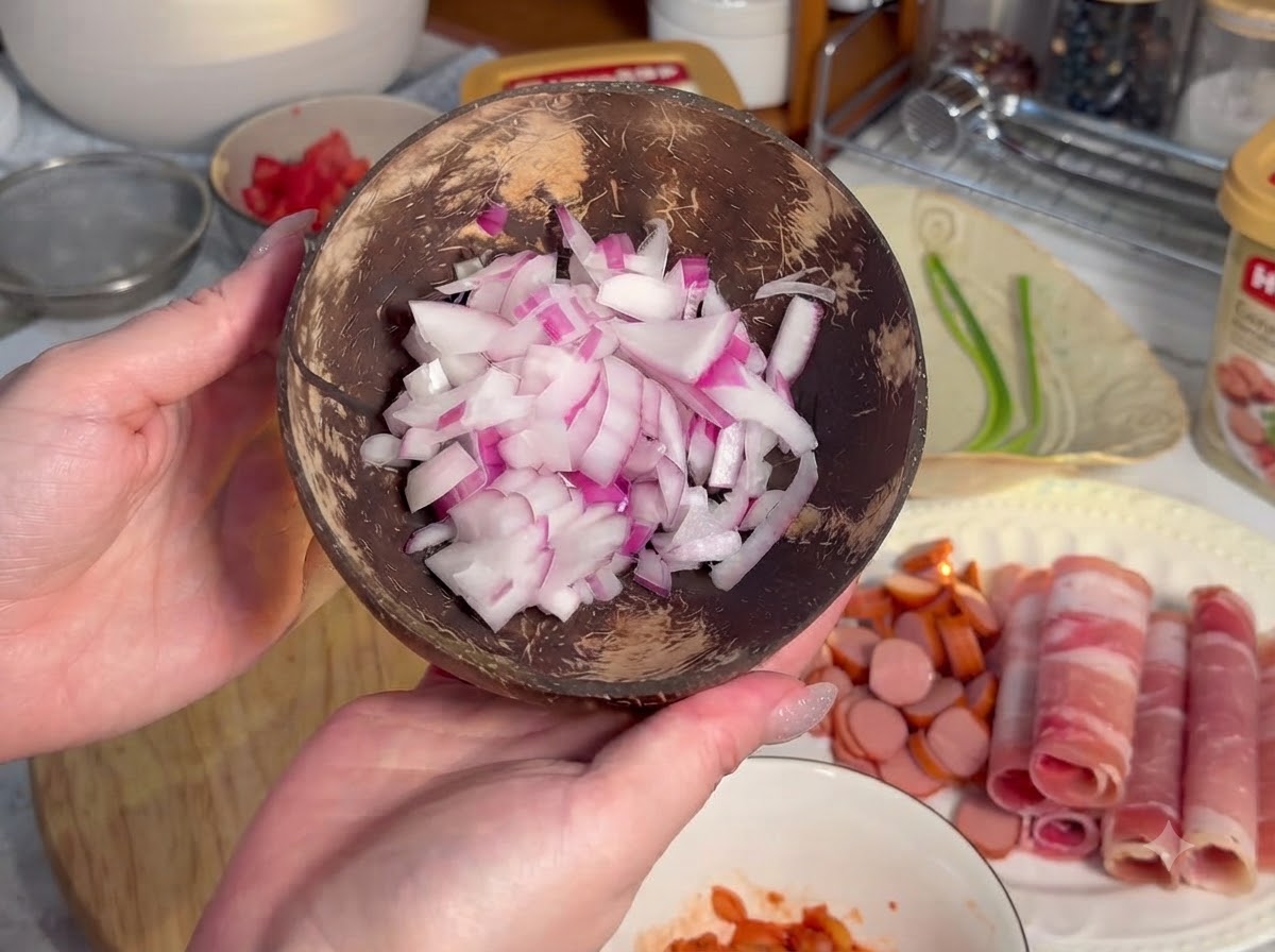 巻いた肉の隣の木製のボードの上に並べられた、小さめの輪切りにされたソーセージ。