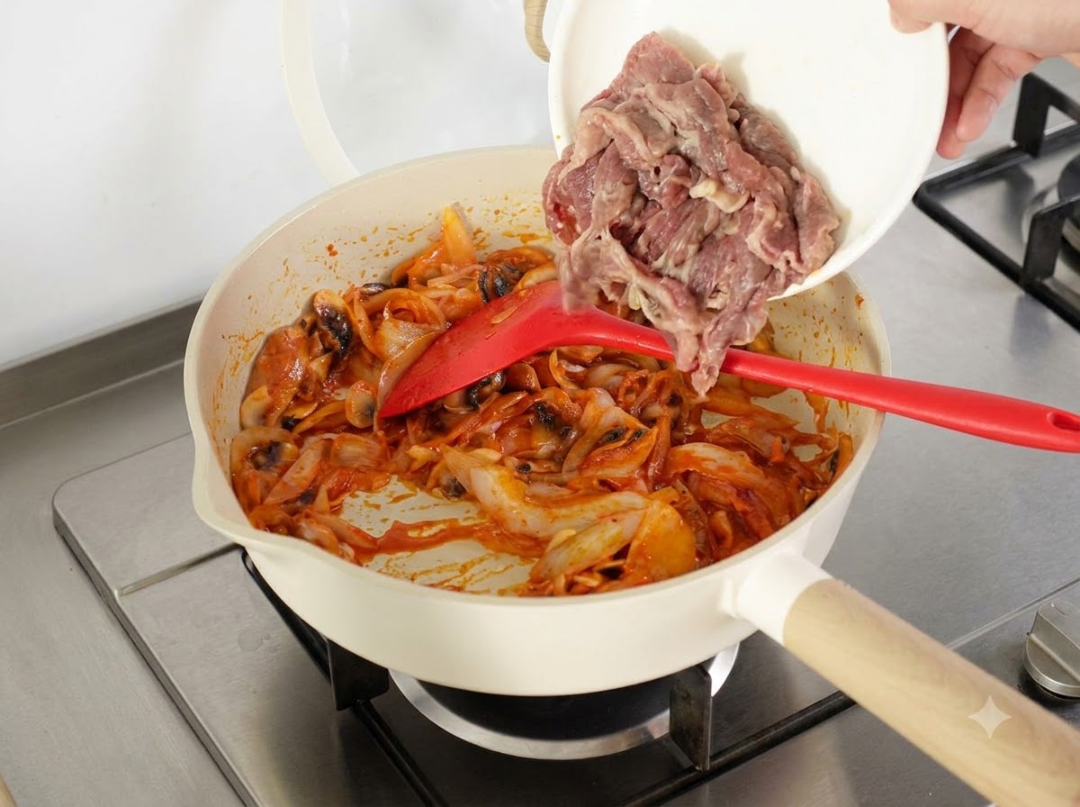 下茹でした牛肉スライスと一晩冷やしたご飯のボウルを、フライパンに加えている様子。
