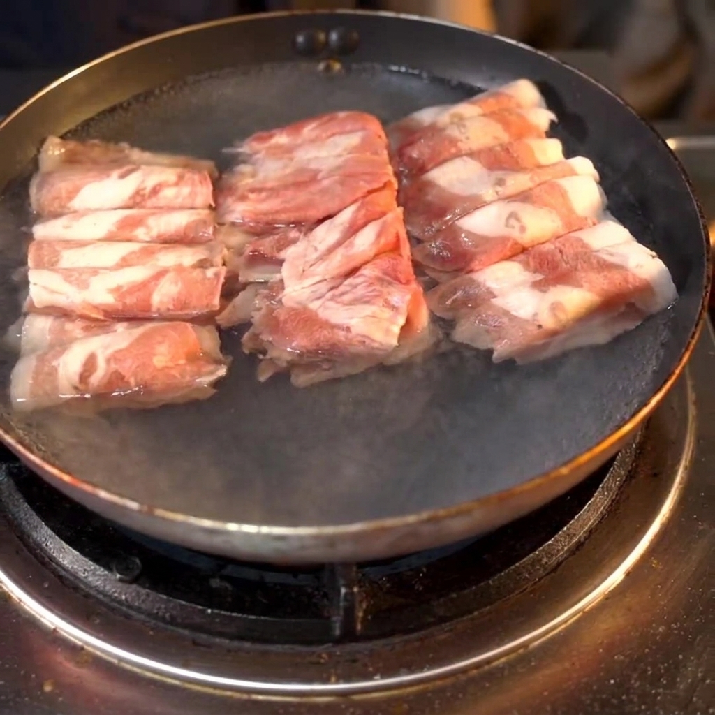 料理酒を加えたお湯の鍋で茹でられる牛肉ロール。