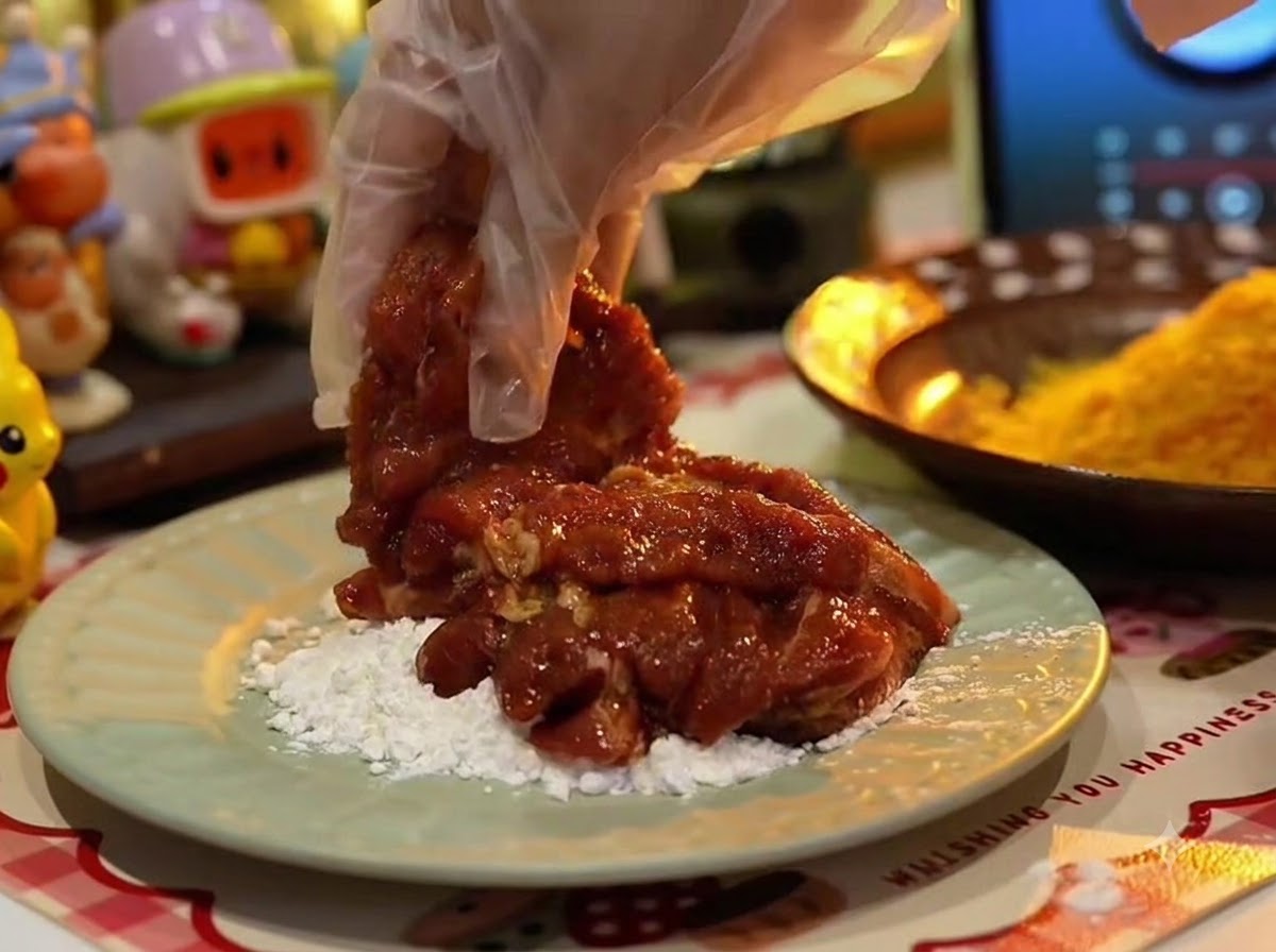 豚肉に白い片栗粉をまぶしている様子