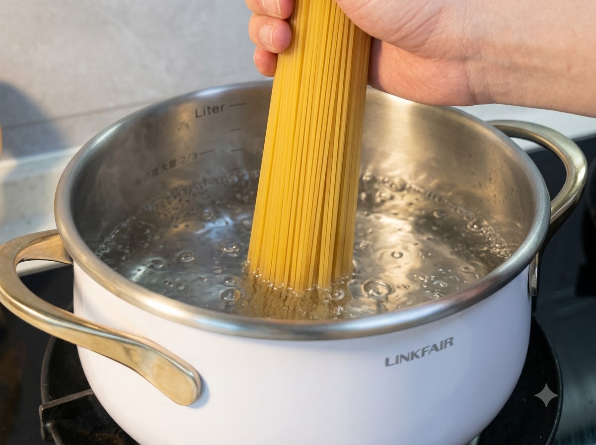 沸騰したお湯の鍋に、乾燥した米麺を片手で垂直に沈めている様子。