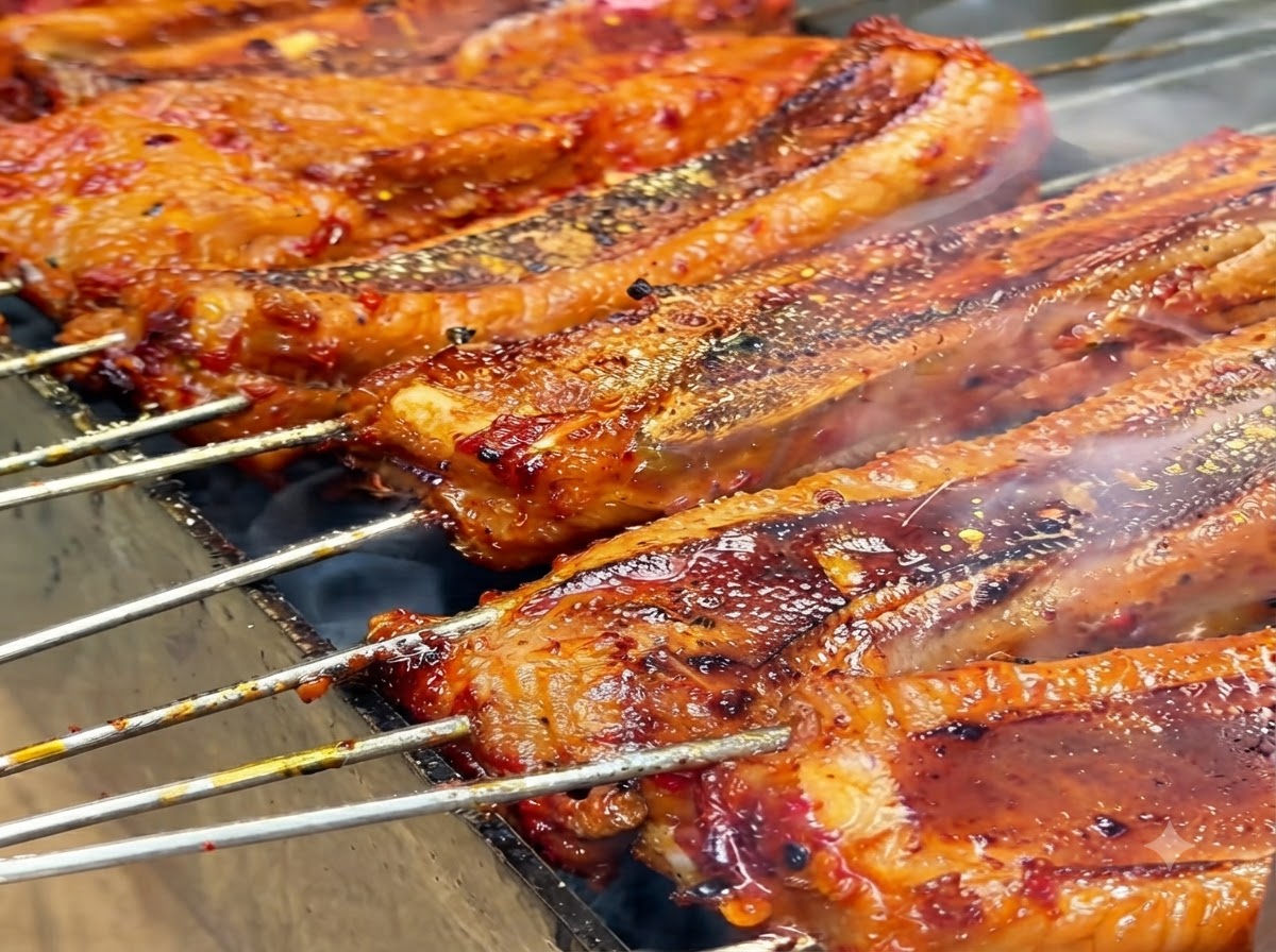 ジュージューと焼けるリブの上に、黄色のスパイスパウダーが振りかけられている様子。