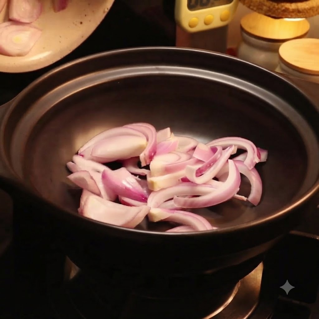 赤玉ねぎのスライスの上に、新鮮な白菜の葉を黒い鍋の中に並べている様子。