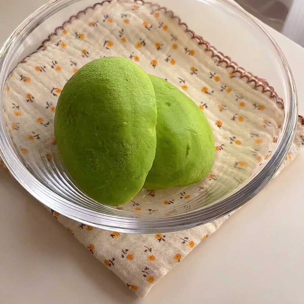ガラスボウルに入った、鮮やかな緑色のアボカドの半身。