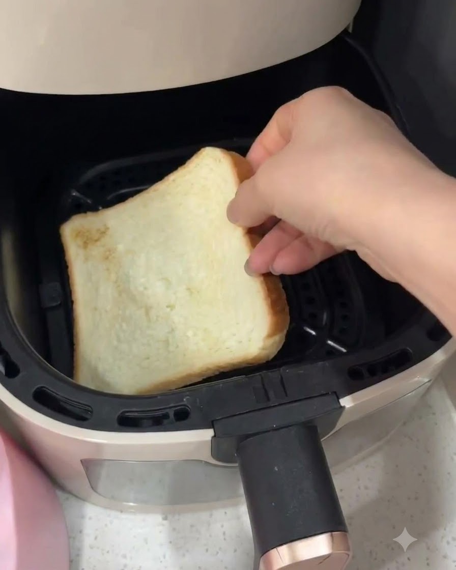 エアフライヤーのバスケットの中に白い食パンの1枚が入れられている様子。