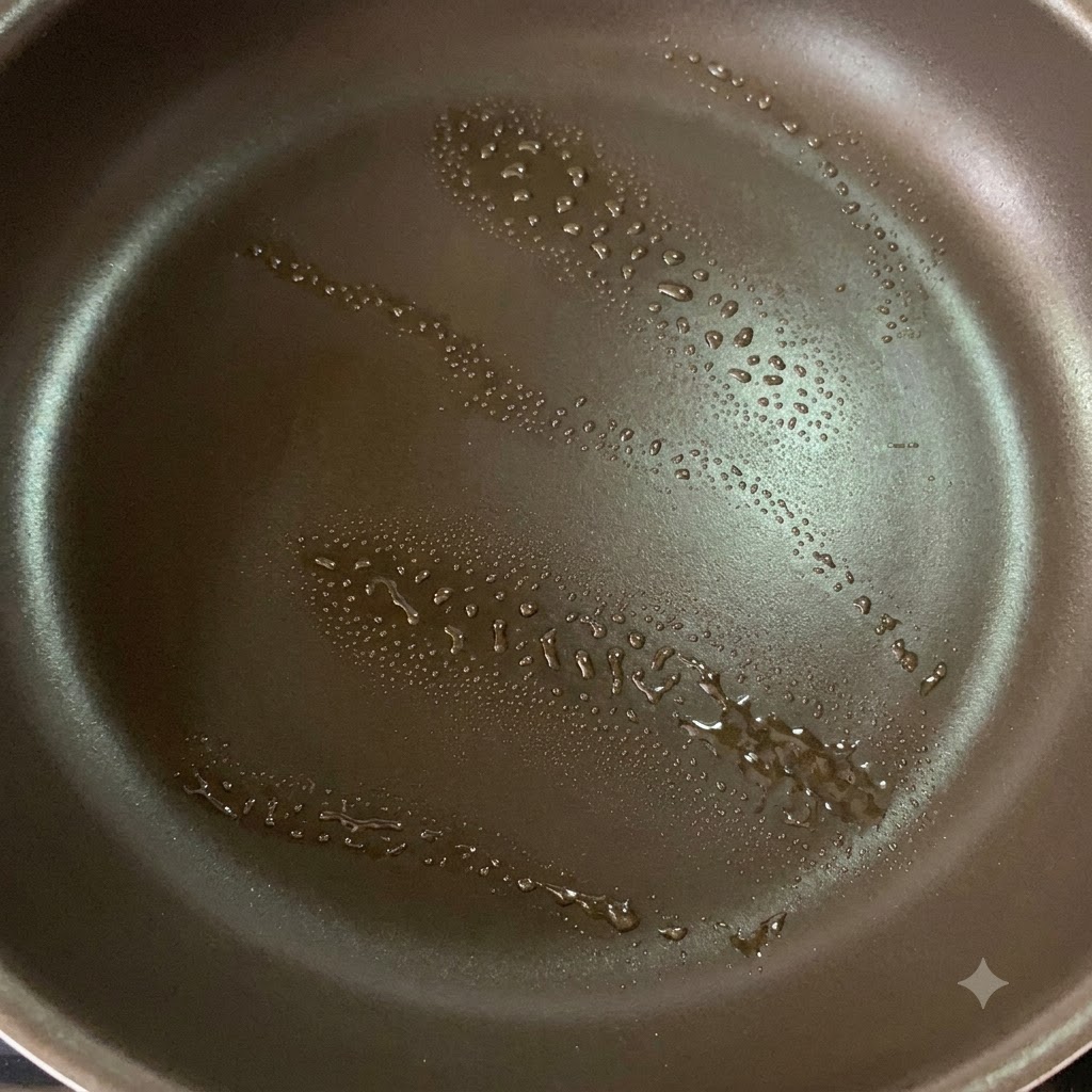 鶏もも肉を焼き付けるために少量の油をスプレーしたノンスティック加工のフライパン。
