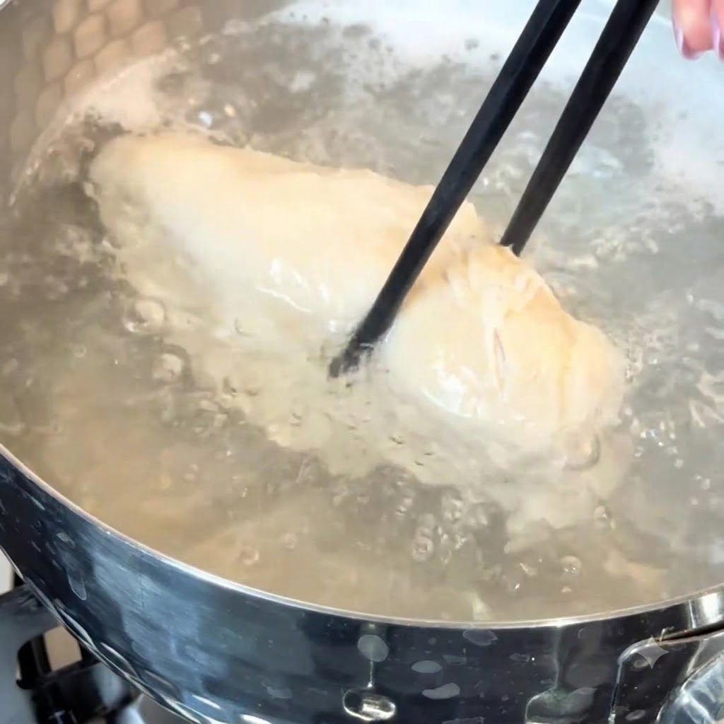 鍋のお湯の中で茹でられている鶏むね肉。