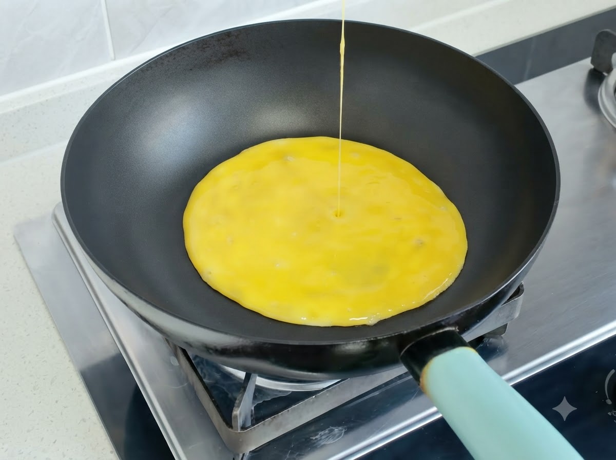 熱したフライパンに注ぎ入れられる溶き卵の混合液。
