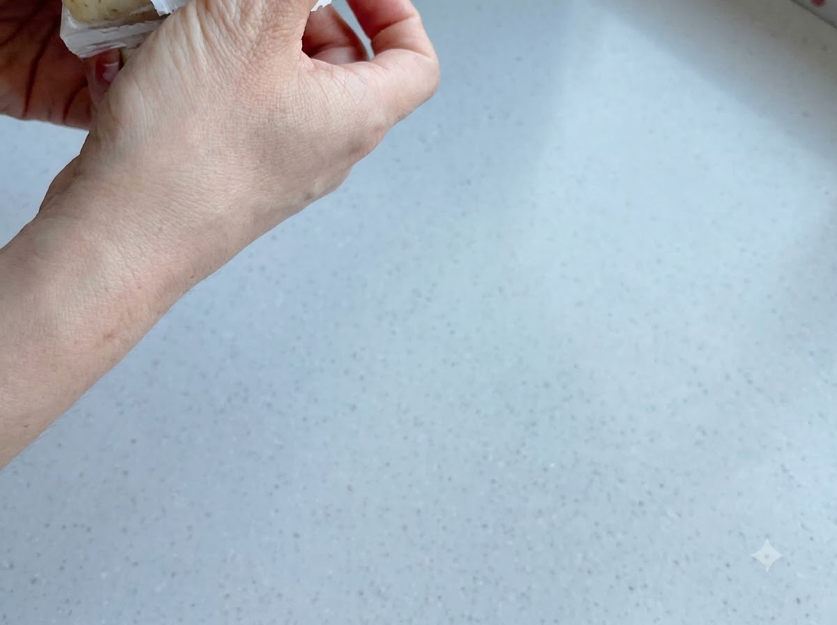 ボウルに入った茹でたじゃがいもと人参の上に振りかけられている黒こしょうとマヨネーズ。