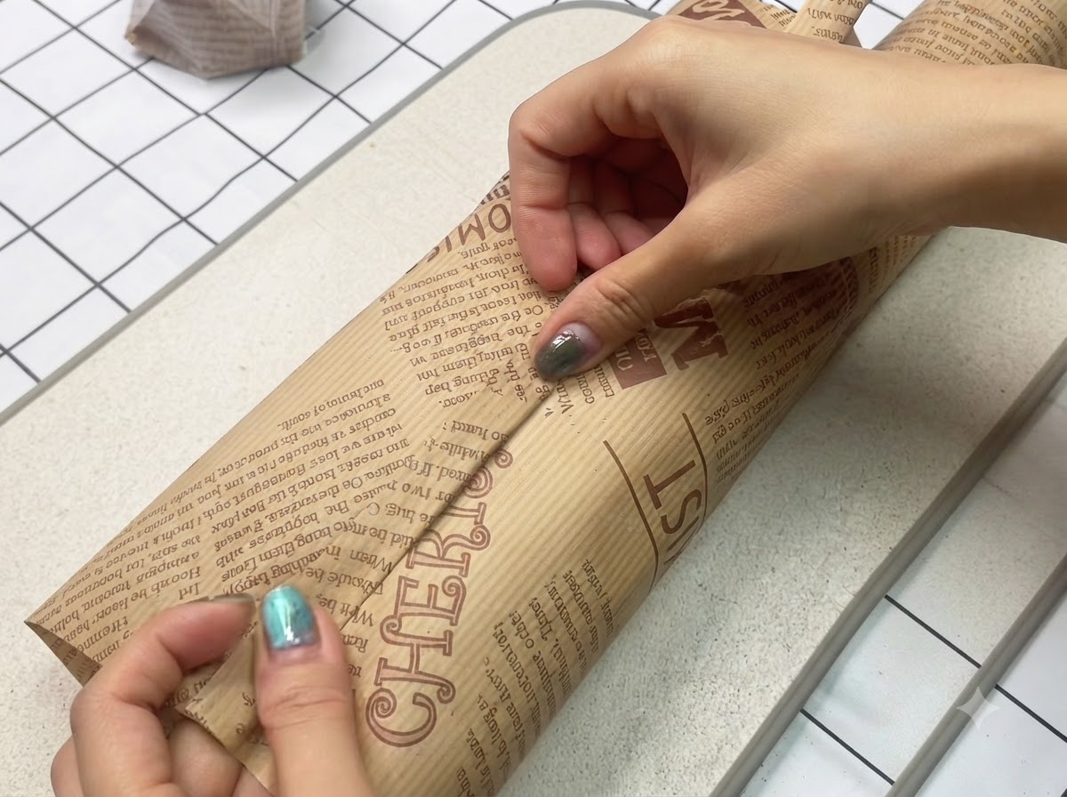 作りたてのサンドイッチが、茶色の装飾用クッキングペーパーできれいにしっかりと包まれているところ。