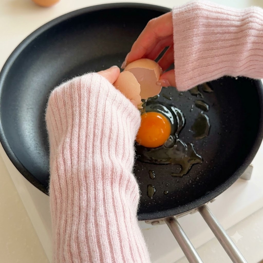 油をひいた熱いフライパンに割り入れられる卵。