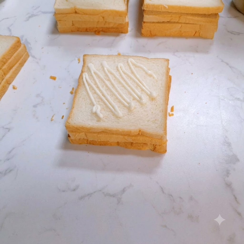 ドレッシングを塗ったパンの上に、味付け調理されたチキンステーキが置かれているところ。