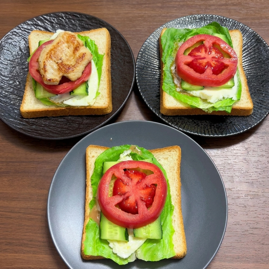 レタス、卵、きゅうり、そして厚切りの新鮮なトマトスライスがトッピングされた全粒粉パンのレイヤー。