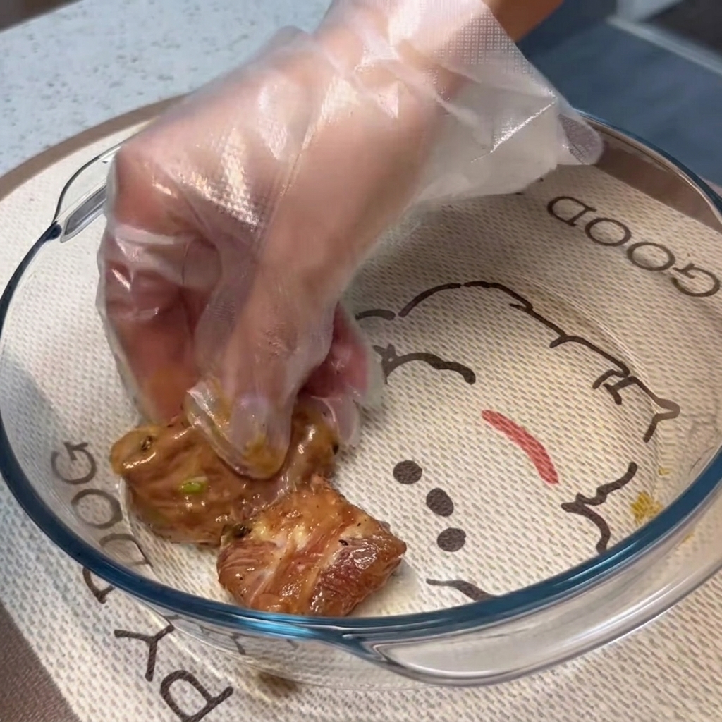 透明な耐熱ガラス皿の上に、下味をつけたスペアリブを重ならないように平らに並べている様子。