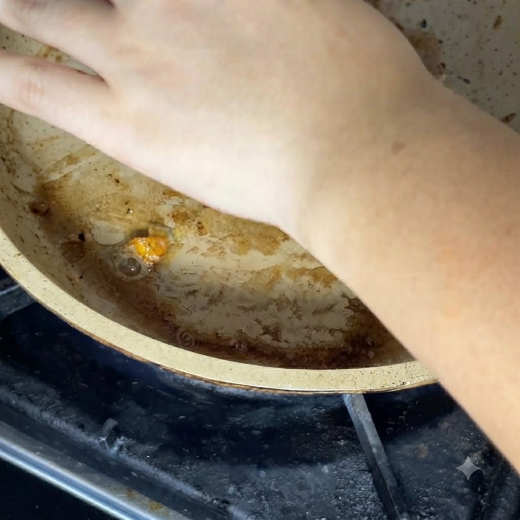 熱いフライパンの中の具材にチーズをのせている手の様子。
