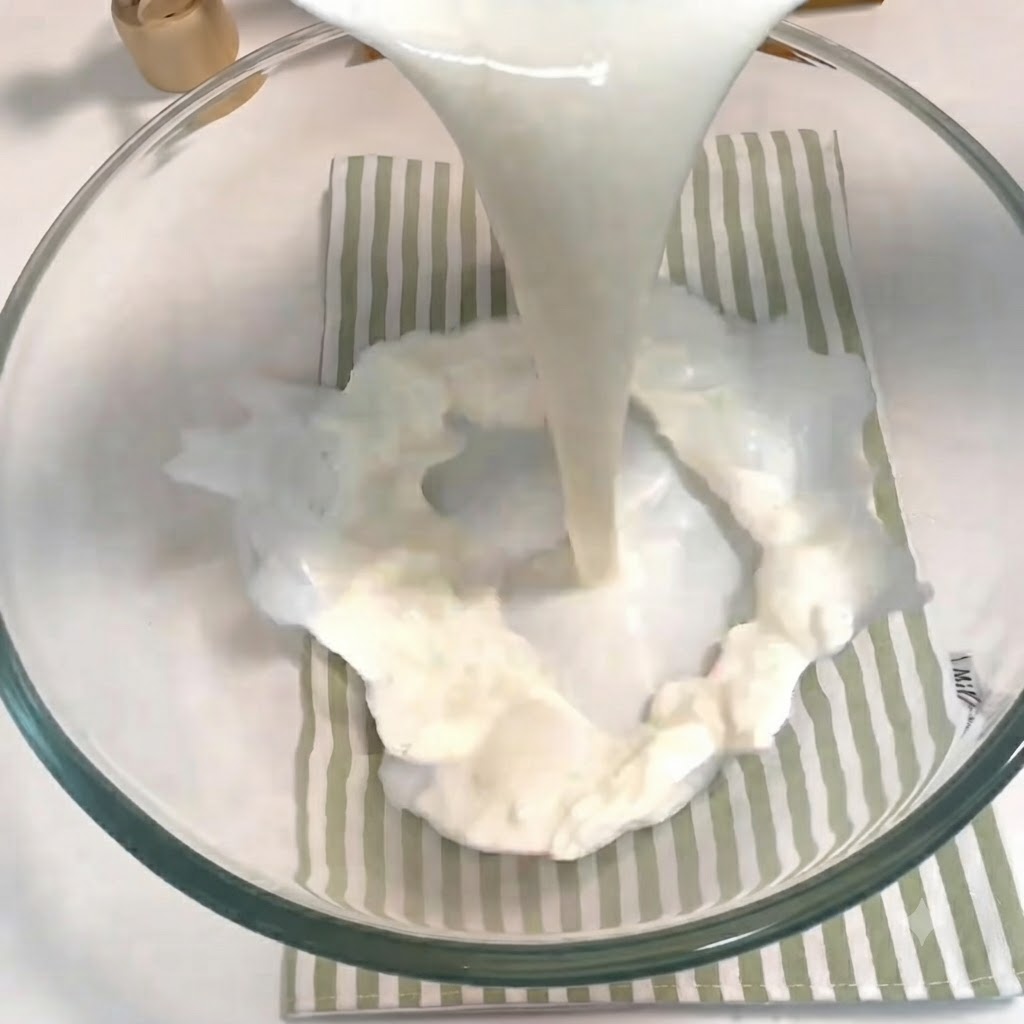ガラスボウルの中で牛乳、砂糖、イースト、卵が注がれ、泡立て器で混ぜ合わされている様子。