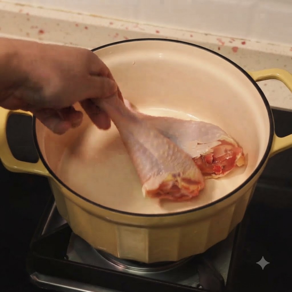 熱した油を入れた鍋で、鶏手羽元がこんがりと焼けている様子。