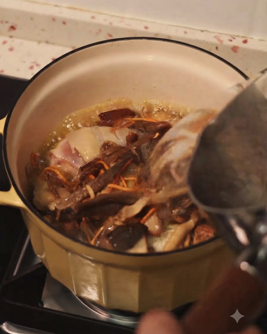 ケトルから、炒めた鶏肉とミックスきのこの入った鍋に熱湯を注いでいる様子。
