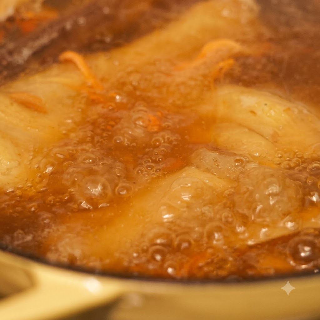 泡立つスープの中で麺と野菜が煮込まれているクローズアップ。