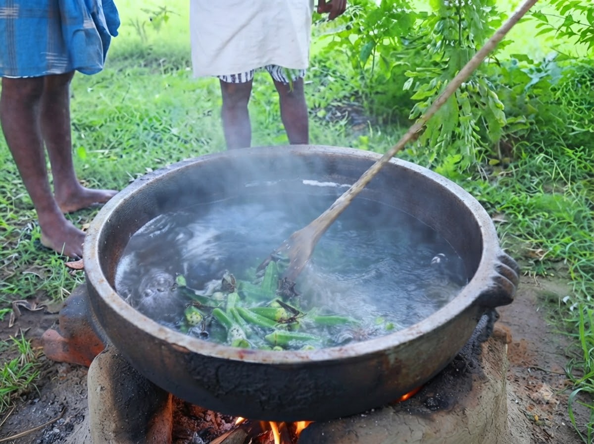 屋外で、枝から新鮮な緑色のカレーリーフを直接、味付けされた油の simmering 中の鍋に剥ぎ取っている様子。