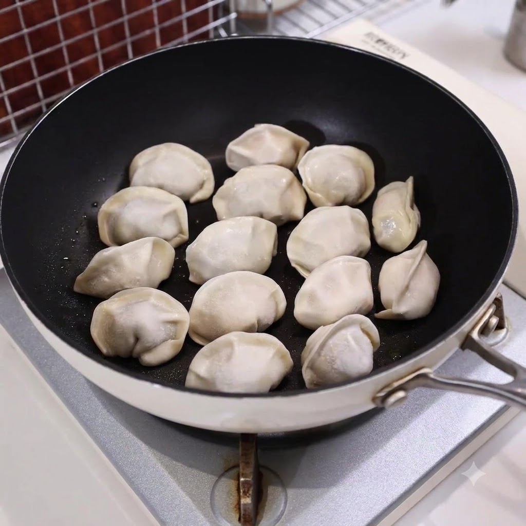 コンロの上で、並べた餃子の半分ほどの高さまで水が入ったフライパン。