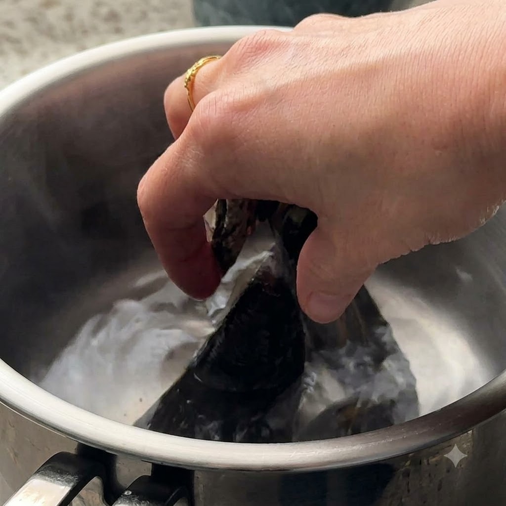 鍋の沸騰したお湯に入れられるアサリとムール貝。