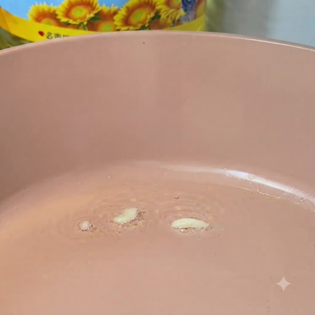 油を引いた熱いピンク色のフライパンで炒められているみじん切りのニンニク。